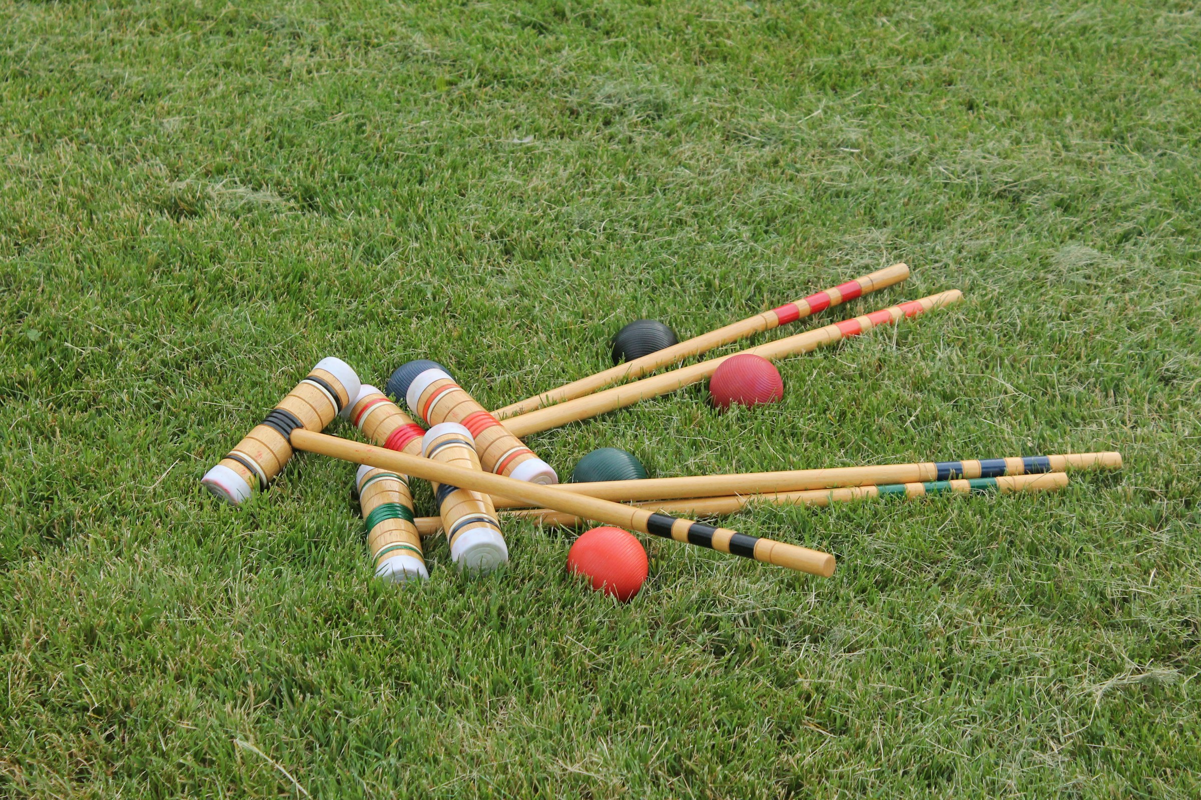 Croquet mallets and balls on a lawn